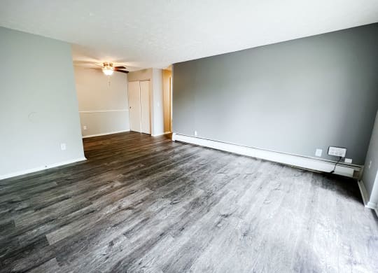 a bedroom with hardwood floors and grey walls  at Summit East - A Senior Community, Ohio, 45237