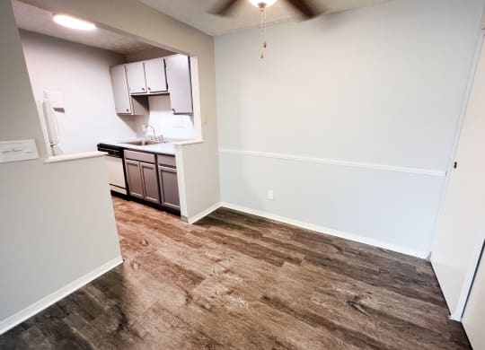 a kitchen with white walls and a wooden floor  at Summit East - A Senior Community, Cincinnati, OH