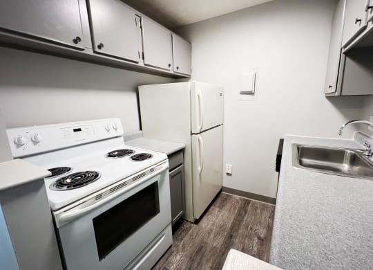 a kitchen with white appliances and white cabinets  at Summit East - A Senior Community, Cincinnati, 45237