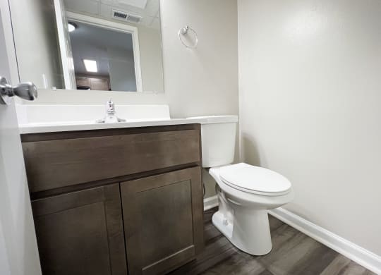 a bathroom with a toilet sink and mirror  at Woodhills Apartments, West Carrollton, 45449