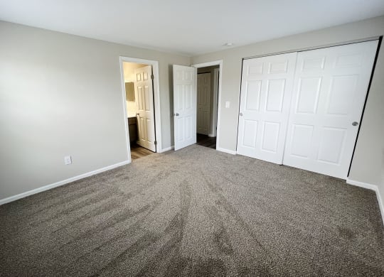 a bedroom with two closets and a door to a bathroom  at Woodhills Apartments, West Carrollton, OH