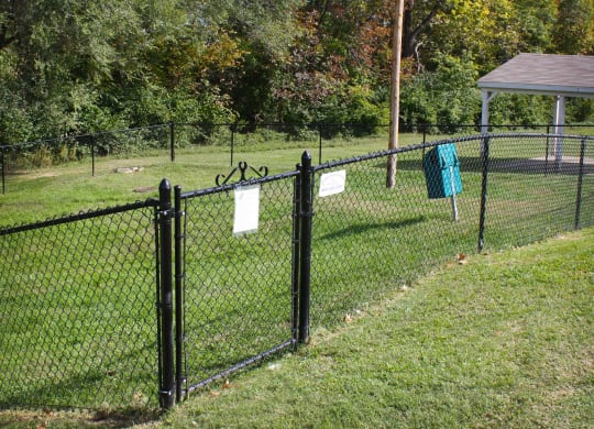 a fence with signs on it in a dog park  at Knobs Pointe Apartments, New Albany, Indiana