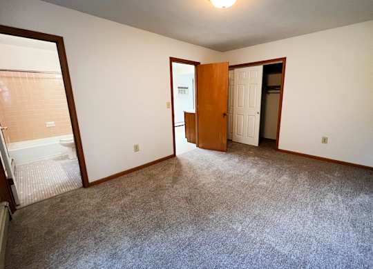 A room with a carpeted floor and a door.
