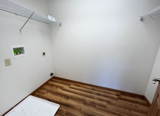 a bathroom with white walls and a wooden floor