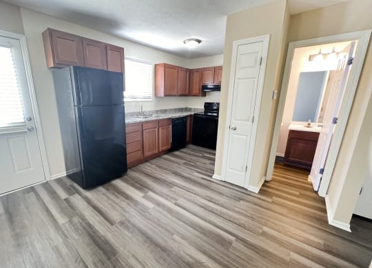 a kitchen with wooden floors and a black refrigerator at The Villas at Kingswood, West Chester, 45069