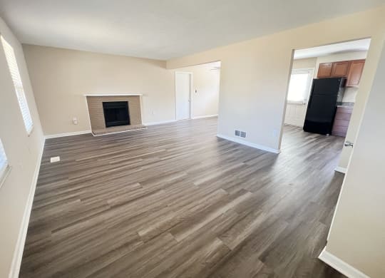 an empty living room with wood flooring and a fireplace at The Villas at Kingswood, West Chester, OH, 45069