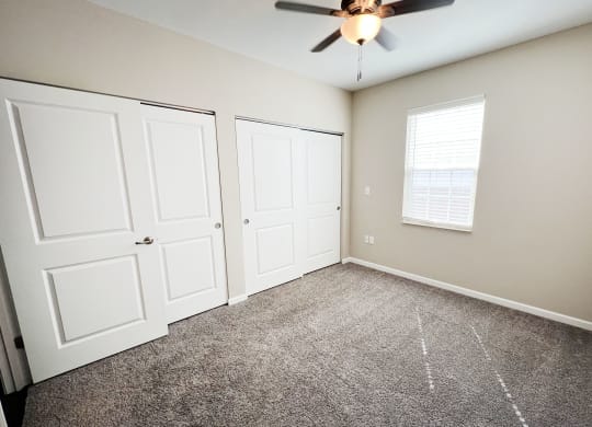a bedroom with two closets and a ceiling fan at Parkway Trails, Florence