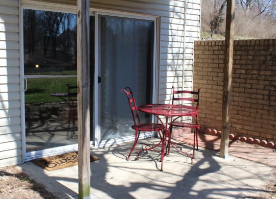a patio with red chairs and a table on a patio  at Timber Ridge Apartments, Cincinnati, OH, 45241