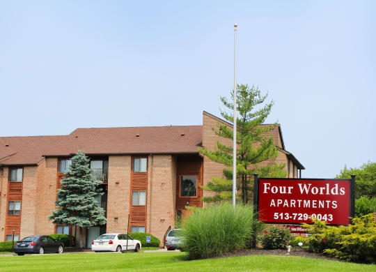 a four worlds apartments sign in front of a brick building  at Four Worlds Apartments, Cincinnati, OH
