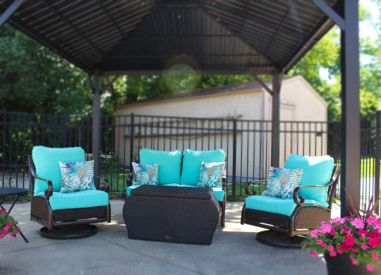 a patio with blue chairs and a gazebo  at Hunter's Creek Apartments, Ohio, 45242