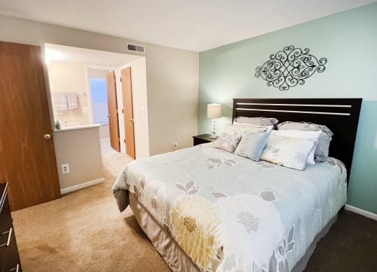 a bedroom with a bed and a door to a bathroom at The Vinings Apartments, Cincinnati, 45245