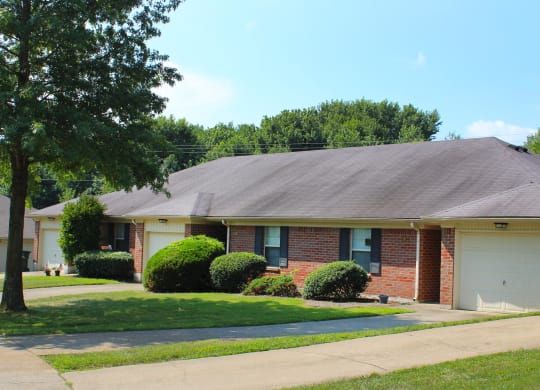 a brick house with a white garage door and a lawn  at Aberdine Place, Kentucky