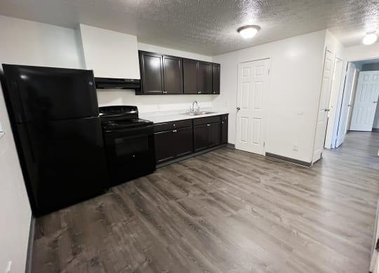 a kitchen with black appliances and white walls at Quail Meadow Apartments, Cincinnati