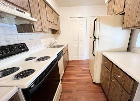 a kitchen with white appliances and wooden cabinets at Concord Woods Apartments, Milford, Ohio 45150