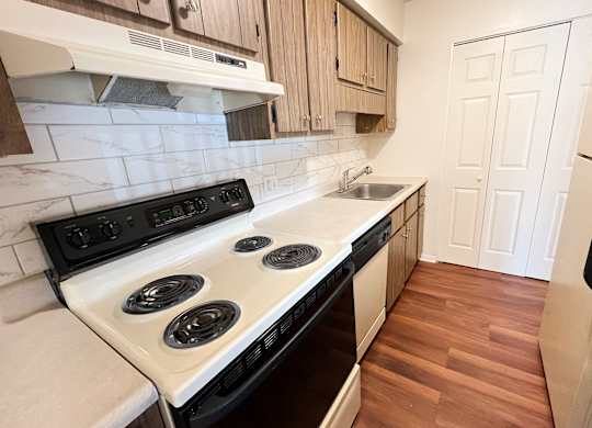 a kitchen with a stove and a sink and a refrigerator at Concord Woods Apartments, Milford, Ohio