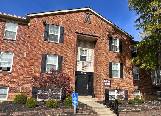 a red brick apartment building with a black door and stairs at Concord Woods Apartments, Milford, Ohio