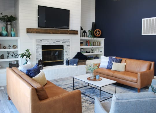 a living room with two leather couches and a fireplace at Steeplechase Apartments, Loveland, 45140