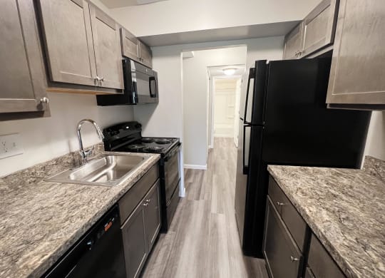a kitchen with gray cabinets and black appliances  at Timber Ridge Apartments, Cincinnati, OH, 45241