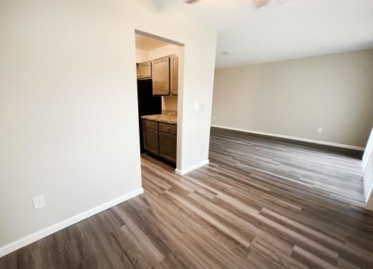 a bedroom with hardwood flooring and a kitchen in the background  at Timber Ridge Apartments, Cincinnati, OH, 45241