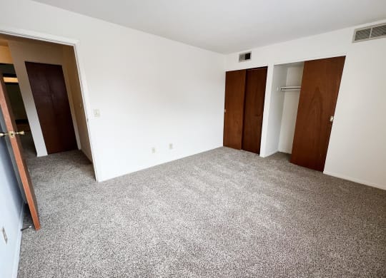 an empty room with three doors and a carpeted floor  at Four Worlds Apartments, Cincinnati, OH, 45231