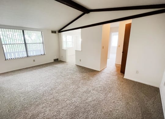 an empty living room with a large window and white walls  at Four Worlds Apartments, Cincinnati, OH