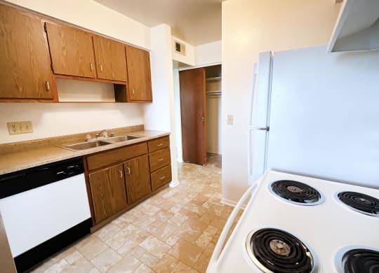 a kitchen with white appliances and brown cabinets  at Four Worlds Apartments, Cincinnati, OH