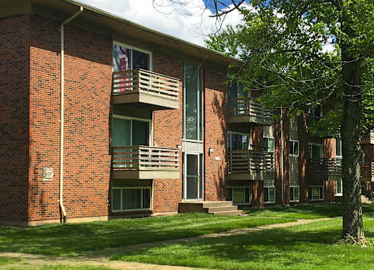 A brick building with a balcony and a flag hanging from it.