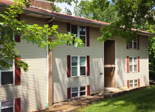 a white house with red shutters and a tree  at Timber Ridge Apartments, Cincinnati, Ohio