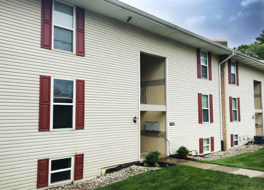 the side of a building with red and white siding and grass at Timber Ridge Apartments, Ohio, 45241