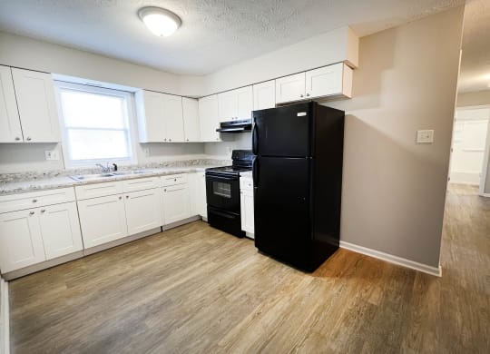 a kitchen with white cabinets and a black refrigerator1 at Park Place, Kentucky, 40475