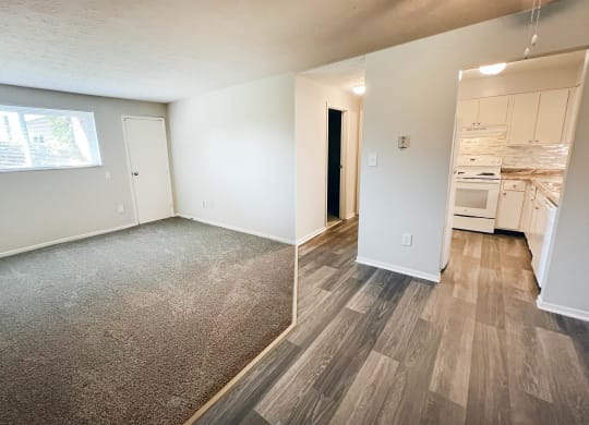 an empty living room and kitchen with wood flooring and a window at Oakwood Apartments, Florence, KY