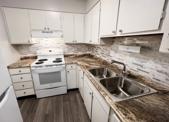Kitchen with appliances and white cabinets at Oakwood Apartments, Florence