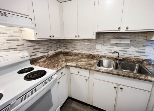 a kitchen with white appliances and granite counter tops at Oakwood Apartments, Florence, Kentucky