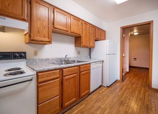 A kitchen with wooden cabinets and a white refrigerator.