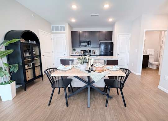 A modern kitchen with a dining table set for two.