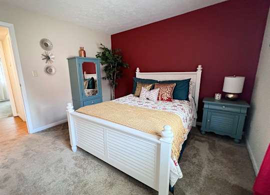 A bedroom with a white bed and a blue cabinet.