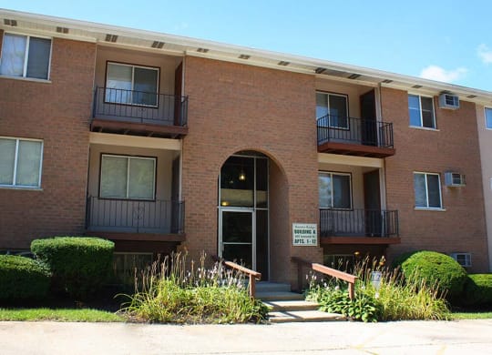a red brick apartment building with an arched doorway at Hunter Ridge Apartments, Cincinnati