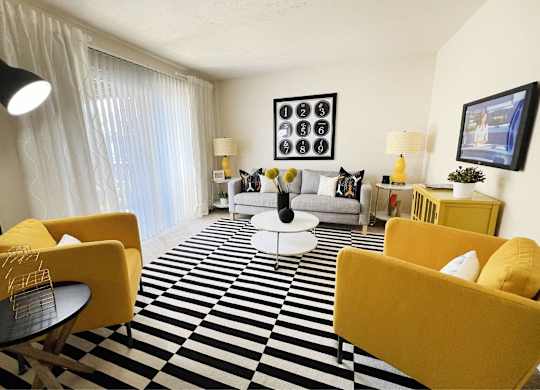 A living room with yellow chairs and a black and white checkered floor.