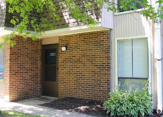 A small building with a brown door and a small window.