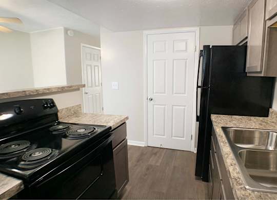 A black stove in a kitchen with a white door in the background.
