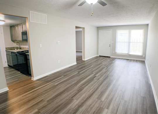 A room with wooden flooring and a ceiling fan.