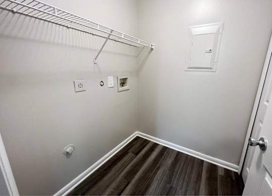 A white wall with a light switch and a white door.
