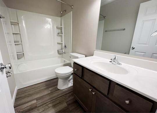 A white bathroom with a toilet, sink, and bathtub.