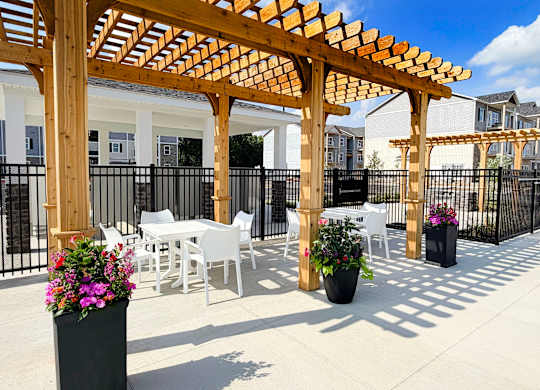 Outdoor patio with white furniture and pergola shade at The Meridian on 32 Apartments, Ohio, 45103