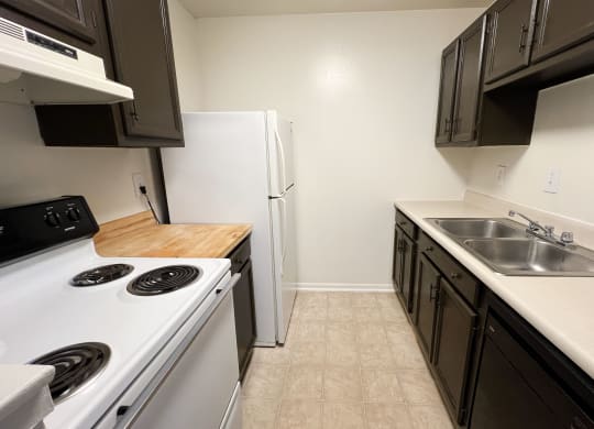 an empty kitchen with a stove sink and refrigerator at Revere Village Apartments, Ohio, 45458