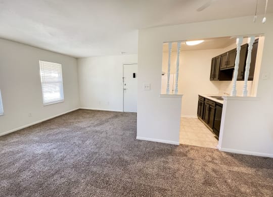 an empty living room and kitchen with a carpeted floorat Revere Village Apartments, Ohio, 45458