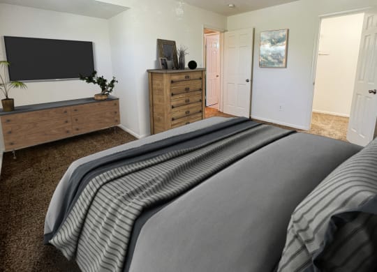 the master bedroom has a large bed and a tvat Revere Village Apartments, Ohio, 45458