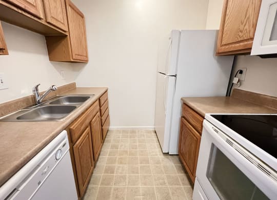 a kitchen with white appliances and wooden cabinetsat Revere Village Apartments, Centerville, Ohio