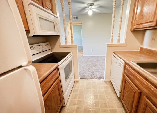 a kitchen with white appliances and wooden cabinetsat Revere Village Apartments, Ohio