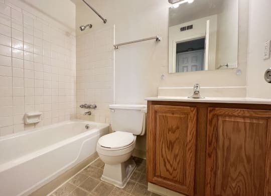 a bathroom with a toilet and a tub and a sinkat Revere Village Apartments, Ohio